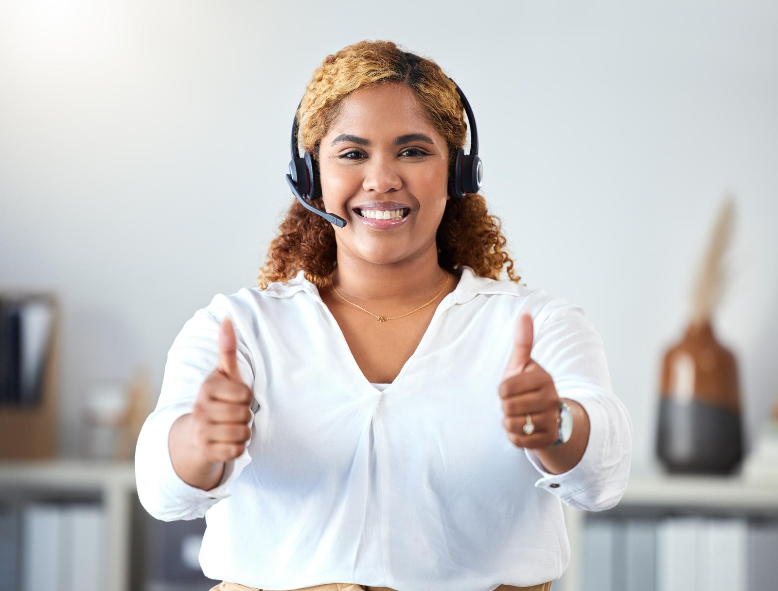 Thumbs up, crm and contact use with a call center agent working in customer service or telemarketing. Thank you, sales and support with a happy business woman working in her office with a headset.